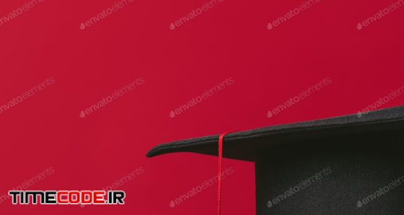 Cropped Image Of Academic Cap On Pile Of Books On Red
