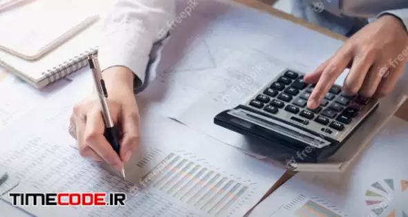 Finance And Accounting Concept. Business Woman Working On Desk Using Calculator 