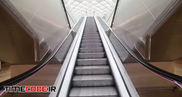 A moving escalator inside a bright airport.