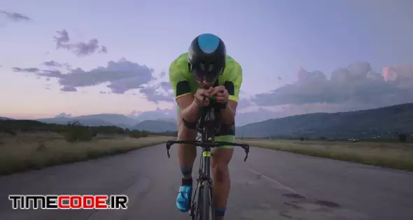 Triathlon sportsman athlete cyclist riding professional racing bicycle. Wearing black sportswear.