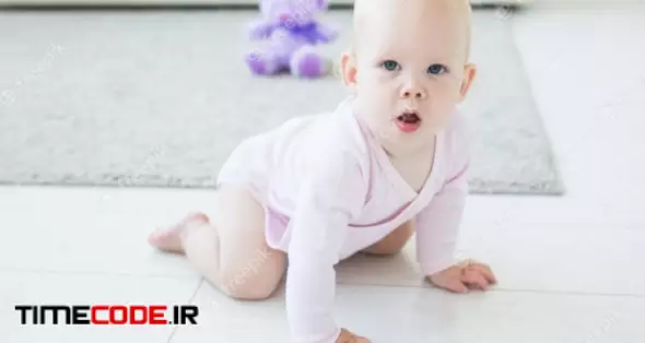 Portrait Of A Cute Baby Crawling And Laughing On The Floor At Home 