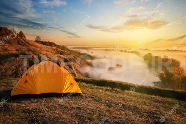 Orange Tent In Canyon Over Misty River At Sunset 