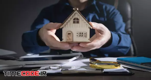 Real Estate Agent Holding House Model. 
