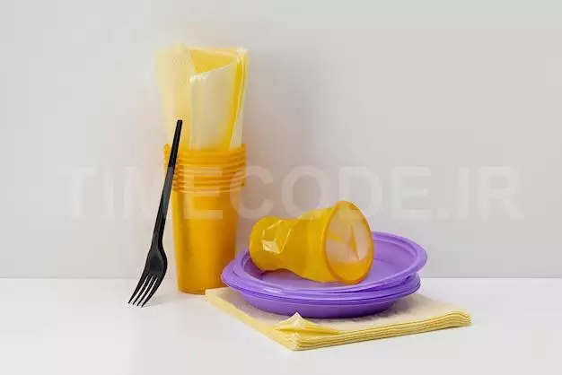 Disposable Yellow Plastic Cups And Lilac Plates, Paper Napkins, Fork.