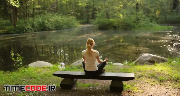 Woman Doing Yoga Sitting on a Bench in the Woods 00:30