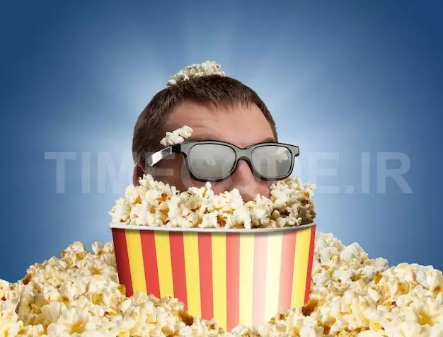 Man In Glasses In A Bucket Of Popcorn Against Blue