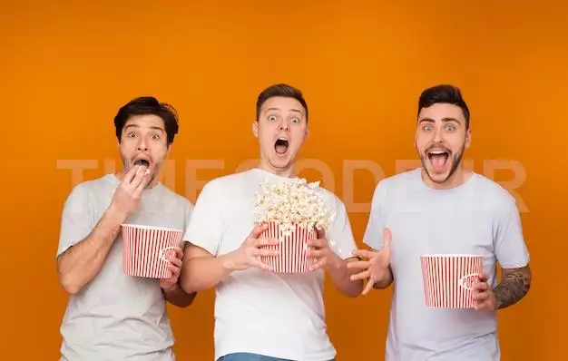 Shocked Men Eating Popcorn And Watching Scary Movie