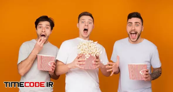 Shocked Men Eating Popcorn And Watching Scary Movie
