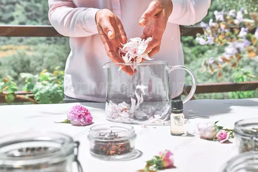 Woman Preparing Roses Water With Pink Rose Petals In Glass Bowl.