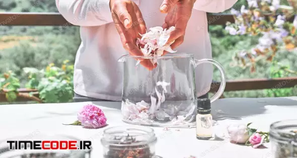 Woman Preparing Roses Water With Pink Rose Petals In Glass Bowl.