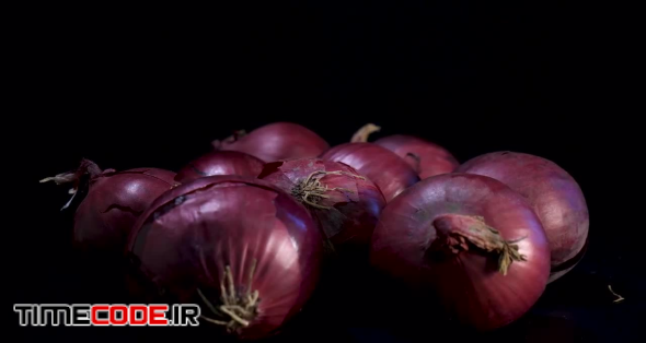 Red Onions Rotate Against Black Background