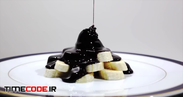 Pouring Black Chocolate On Bananas