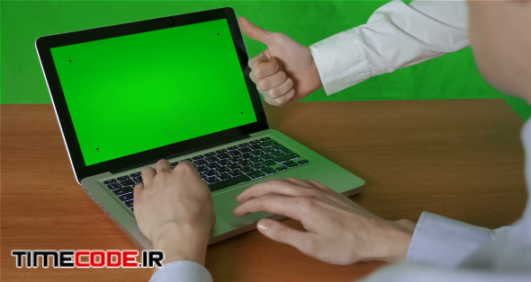 Business people working on a laptop With a green screen and approve the draft (work)show thumb up for approval .With a green screen background.chroma key.