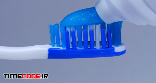 Macro Close Up Putting Blue Toothpaste On A Toothbrush