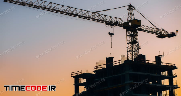 Crane And Building Construction Site On Background Of Sunset Sky