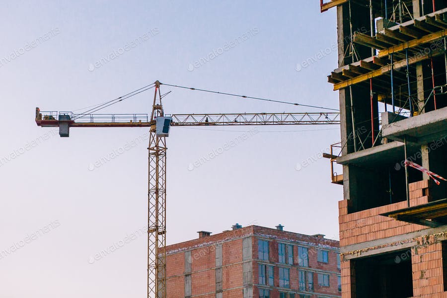 Crane And Building Construction Site On Background Of Sky