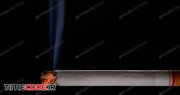 Lit And Burning Cigarette With Smoke On Black Background