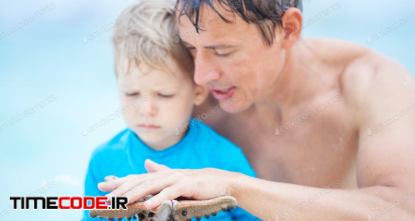 Father And Son Watching Starfish Sticking To Man