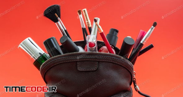 Make-up Bag With Cosmetics And Makeup Accessories Against Red Background
