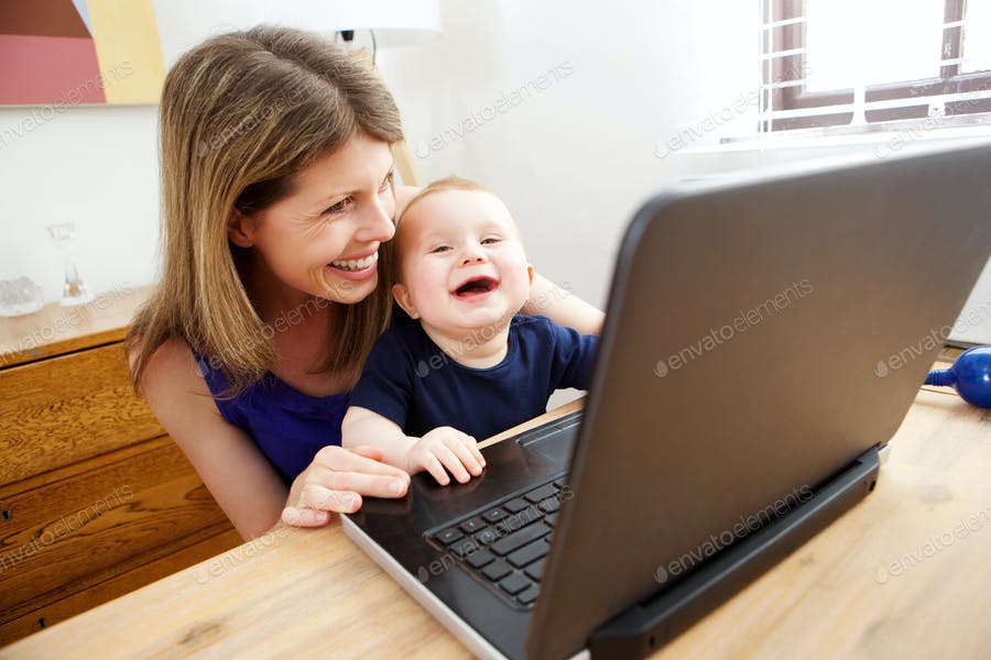 Happy Mother And Baby Using Laptop And Smiling