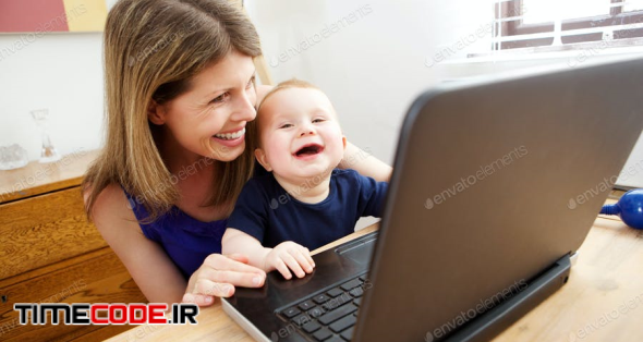Happy Mother And Baby Using Laptop And Smiling
