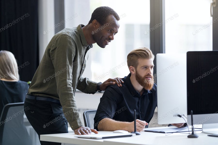 Two Young Business Men Working Together On A Computer