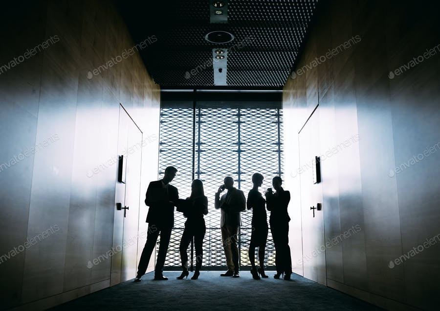 Silhouettes Of Business People In Modern Office Interior