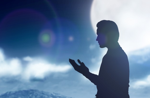 Silhouette Of Muslim Man Standing While Raised Hands And Praying With The Night Scene Background 