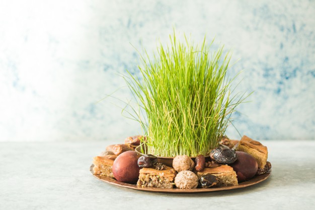 Novruz Traditional Tray With Green Wheat Grass Semeni Or Sabzi, Sweets And Dry Fruits Pakhlava On White Background. Spring Equinox, Azerbaijan Copy Space 